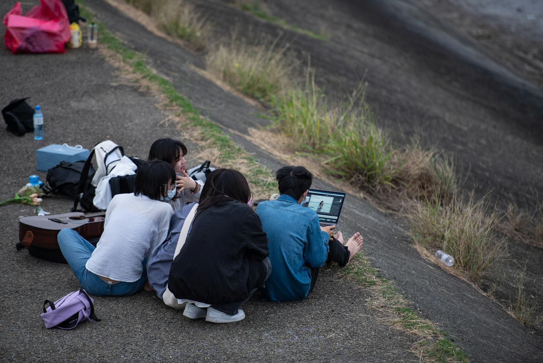 young people using a laptop outdoors