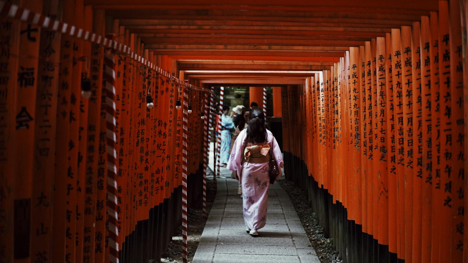 woman walking in torii gates